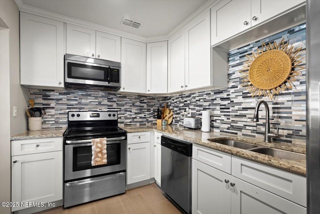 kitchen with white cabinets, sink, stainless steel appliances, and tasteful backsplash