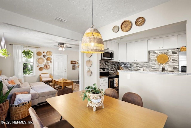 dining space with ceiling fan and a textured ceiling