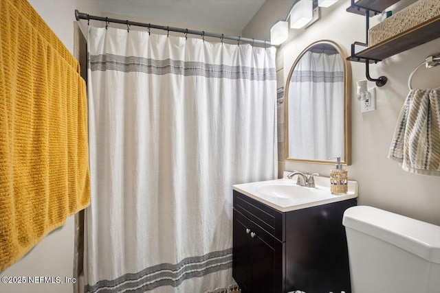 bathroom featuring a shower with shower curtain, vanity, and toilet