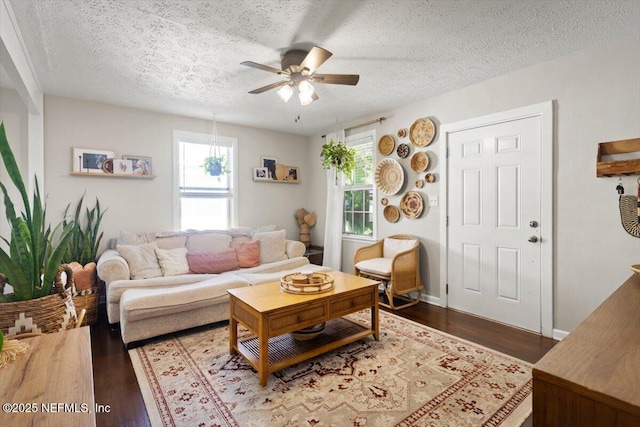 living room with dark hardwood / wood-style flooring, a textured ceiling, and ceiling fan