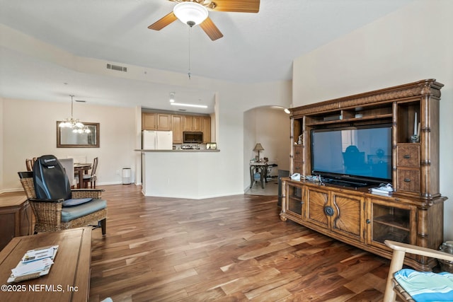 living room with ceiling fan with notable chandelier and dark wood-type flooring