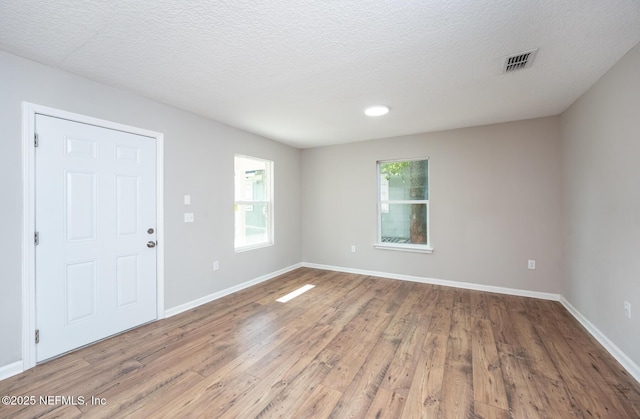 empty room featuring hardwood / wood-style floors and a textured ceiling