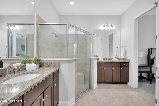 bathroom with tile patterned flooring, vanity, and walk in shower