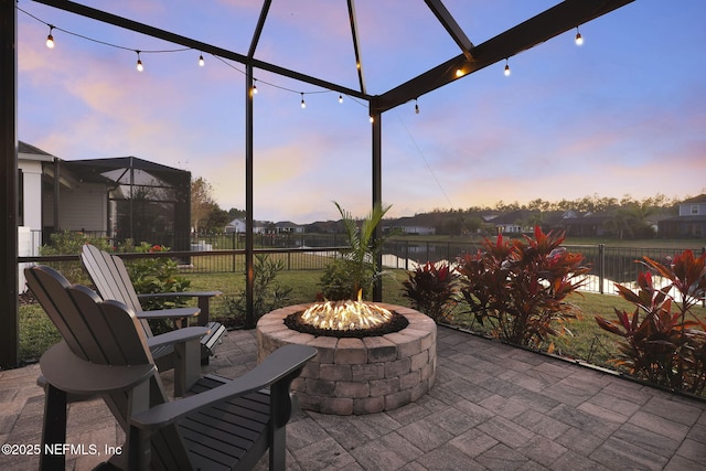 patio terrace at dusk with a water view and an outdoor fire pit