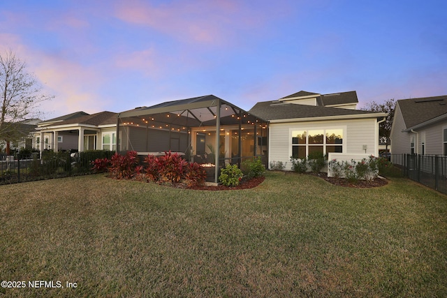 view of front of house featuring a lawn and glass enclosure