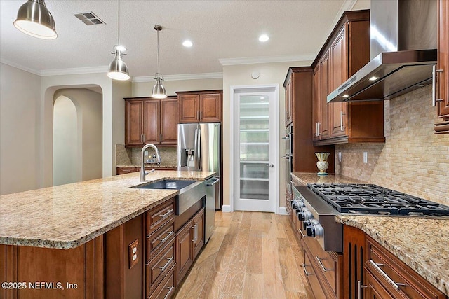 kitchen with wall chimney exhaust hood, a spacious island, backsplash, and appliances with stainless steel finishes