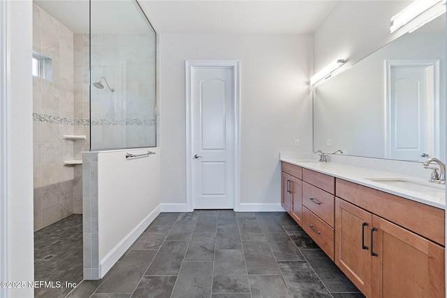 bathroom with a tile shower and vanity