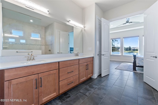 bathroom featuring tiled shower, vanity, a water view, and ceiling fan