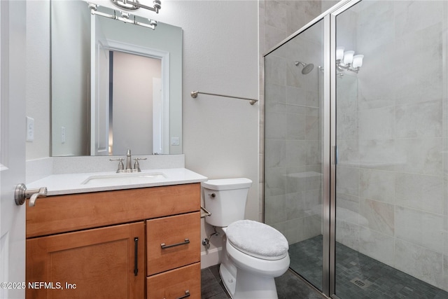 bathroom featuring a shower with door, vanity, and toilet