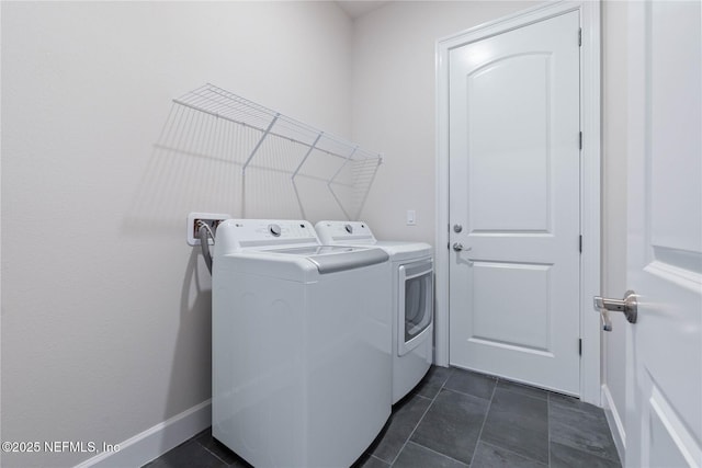 laundry room featuring dark tile patterned flooring and washing machine and dryer