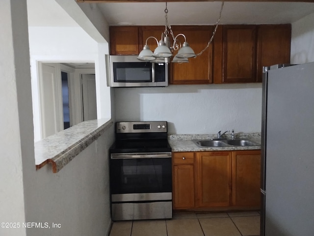 kitchen featuring a chandelier, appliances with stainless steel finishes, light tile patterned floors, and sink