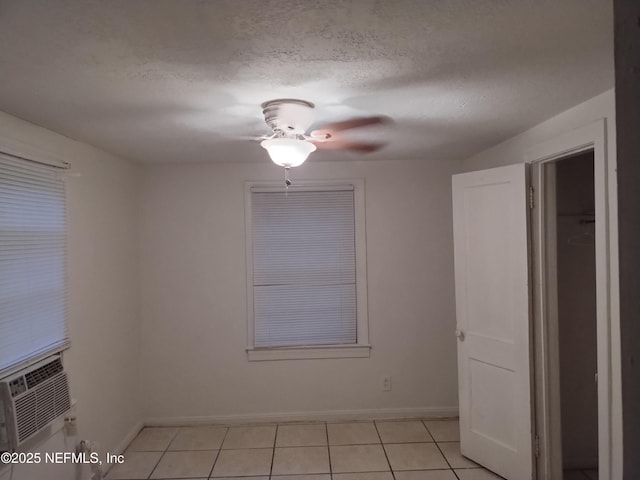 tiled spare room with cooling unit and a textured ceiling