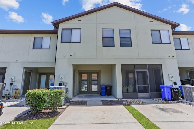 rear view of property featuring central AC unit and french doors