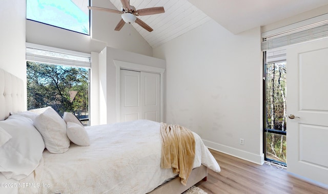 bedroom with lofted ceiling, hardwood / wood-style floors, a closet, and ceiling fan