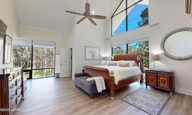 bedroom with light wood-type flooring, high vaulted ceiling, and ceiling fan