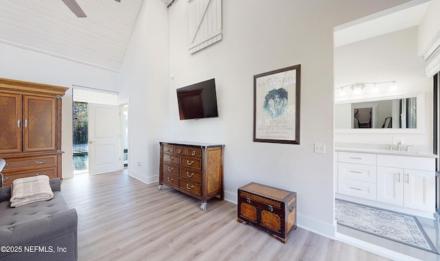 sitting room with high vaulted ceiling, ceiling fan, light hardwood / wood-style flooring, and sink