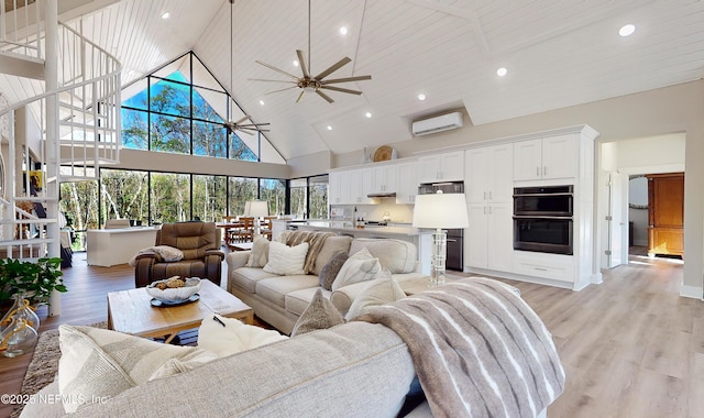 living room featuring wood ceiling, ceiling fan, a wall mounted air conditioner, high vaulted ceiling, and light hardwood / wood-style flooring