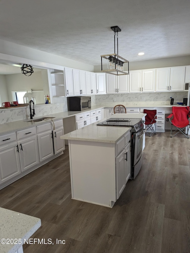 kitchen with white cabinetry, sink, dark wood-type flooring, pendant lighting, and range