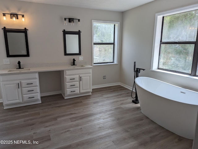 bathroom featuring hardwood / wood-style flooring, plenty of natural light, and a tub