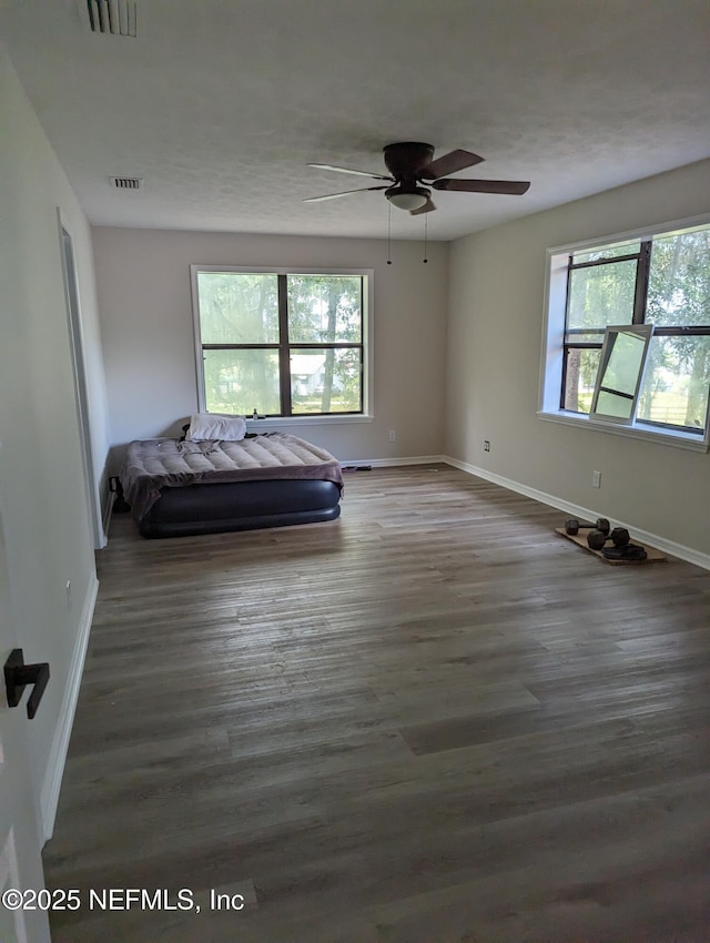 unfurnished bedroom featuring dark hardwood / wood-style flooring and ceiling fan