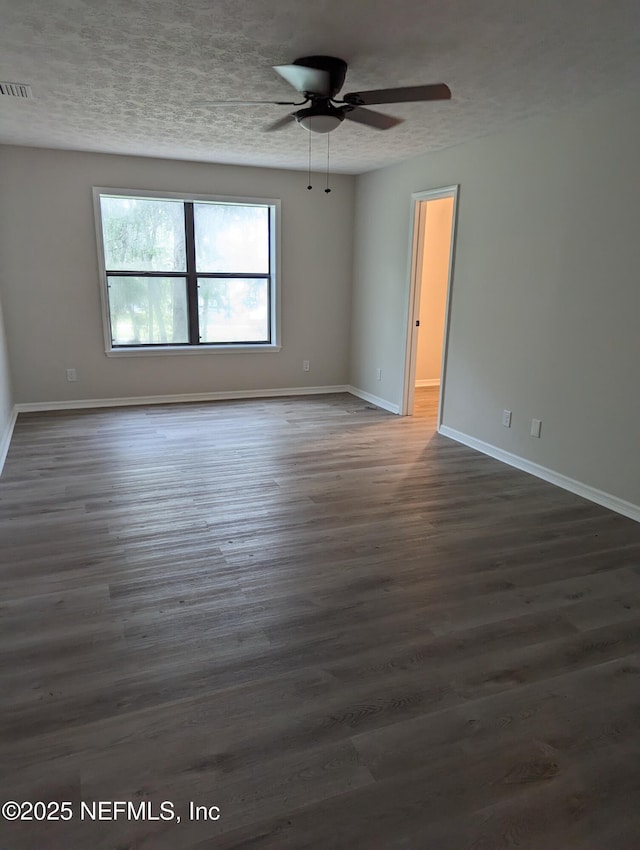 empty room featuring ceiling fan and dark wood-type flooring