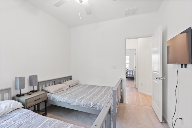 bedroom with ceiling fan, visible vents, and light colored carpet