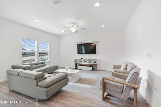 living room featuring baseboards, visible vents, wood finish floors, and recessed lighting