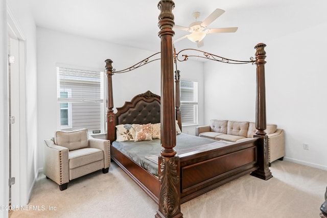 bedroom featuring multiple windows, baseboards, a ceiling fan, and light colored carpet