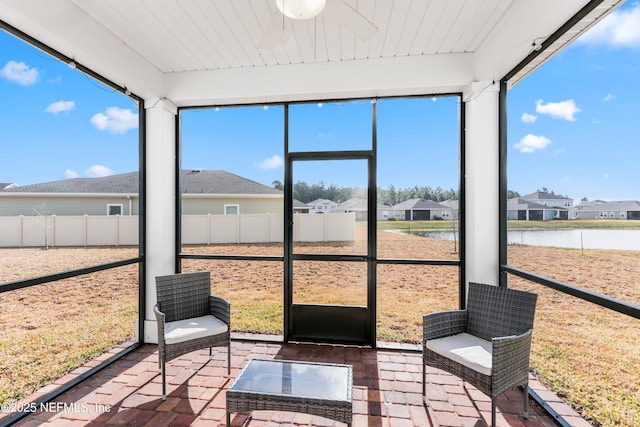 sunroom / solarium featuring a water view, wood ceiling, and a residential view