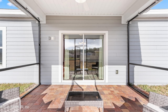 entrance to property with a patio area and ceiling fan