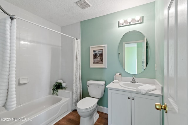 full bathroom featuring wood-type flooring, shower / bath combination with curtain, vanity, toilet, and a textured ceiling