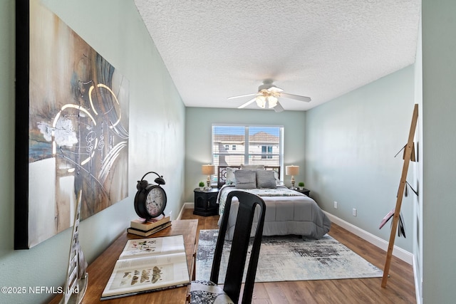 bedroom featuring ceiling fan, hardwood / wood-style floors, and a textured ceiling