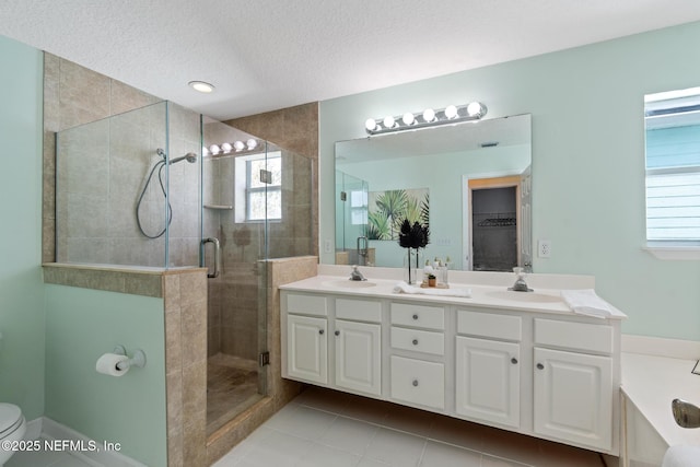 bathroom featuring vanity, walk in shower, toilet, tile patterned floors, and a textured ceiling