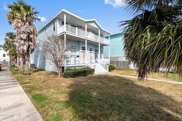 view of front of home featuring central AC, a front lawn, and a balcony