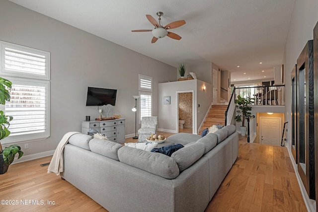 living room featuring ceiling fan, a healthy amount of sunlight, and light wood-type flooring