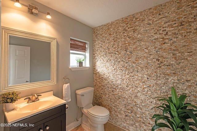 bathroom with vanity, toilet, and a textured ceiling