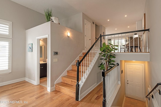 staircase with plenty of natural light and wood-type flooring