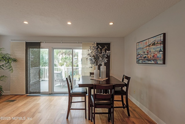 dining area featuring hardwood / wood-style floors and a textured ceiling