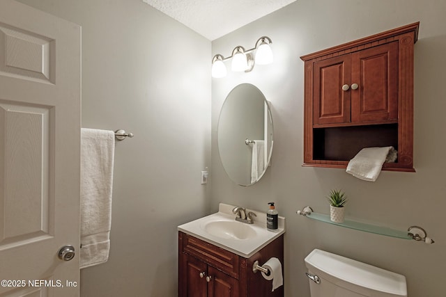 bathroom with vanity, a textured ceiling, and toilet