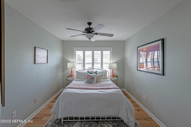 bedroom with ceiling fan, a textured ceiling, and light wood-type flooring