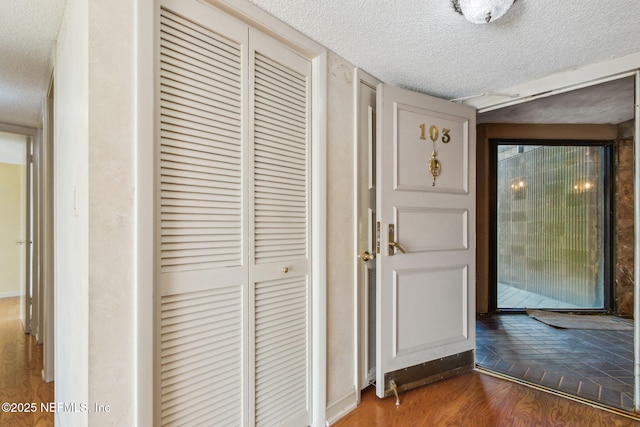 hall featuring dark hardwood / wood-style floors and a textured ceiling