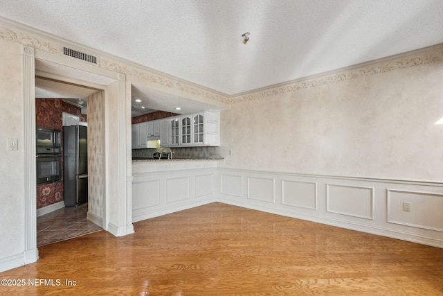 interior space featuring sink, light hardwood / wood-style floors, and a textured ceiling