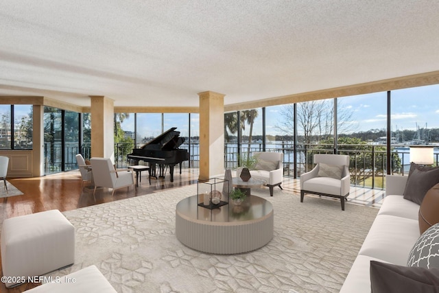 living room featuring hardwood / wood-style floors, expansive windows, a healthy amount of sunlight, and a water view