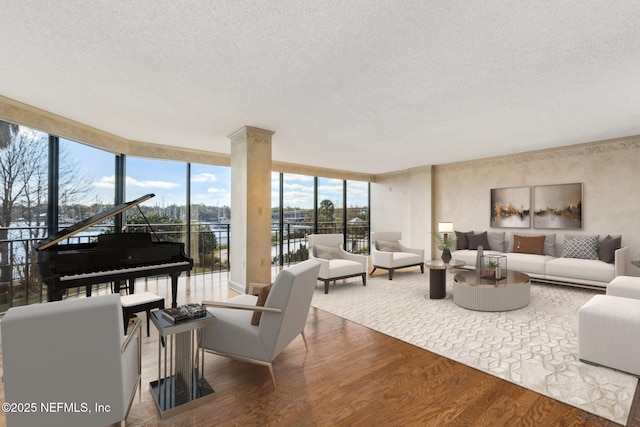 living room with floor to ceiling windows, hardwood / wood-style floors, and a textured ceiling