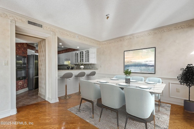 dining area featuring hardwood / wood-style floors and a textured ceiling