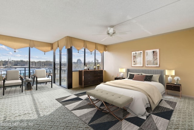 carpeted bedroom featuring a water view, access to outside, multiple windows, and a textured ceiling