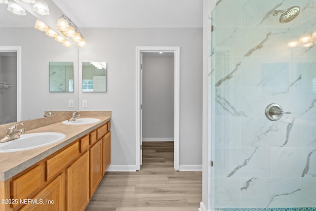 bathroom featuring tiled shower, hardwood / wood-style floors, and vanity