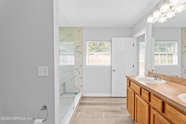 bathroom featuring vanity, tiled shower, and hardwood / wood-style flooring