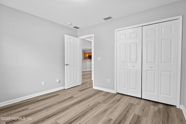 unfurnished bedroom featuring a closet and light wood-type flooring