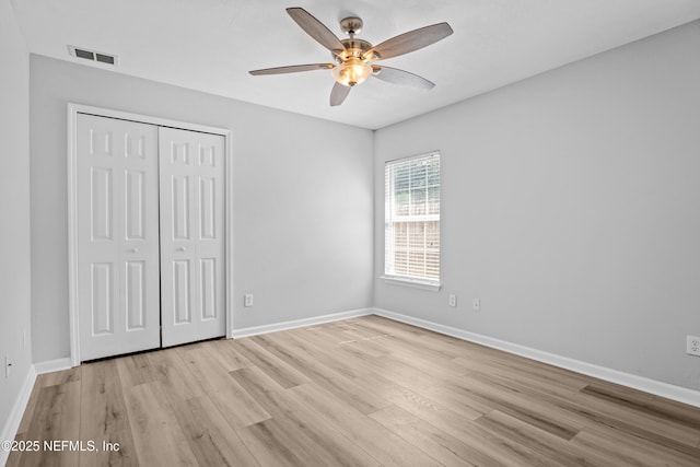 unfurnished bedroom featuring ceiling fan, a closet, and light hardwood / wood-style flooring